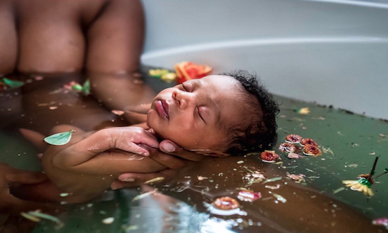 Newborn baby in herb bath